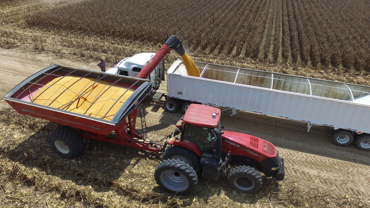 Aerial view of a tractor and a load of grain being transferred.