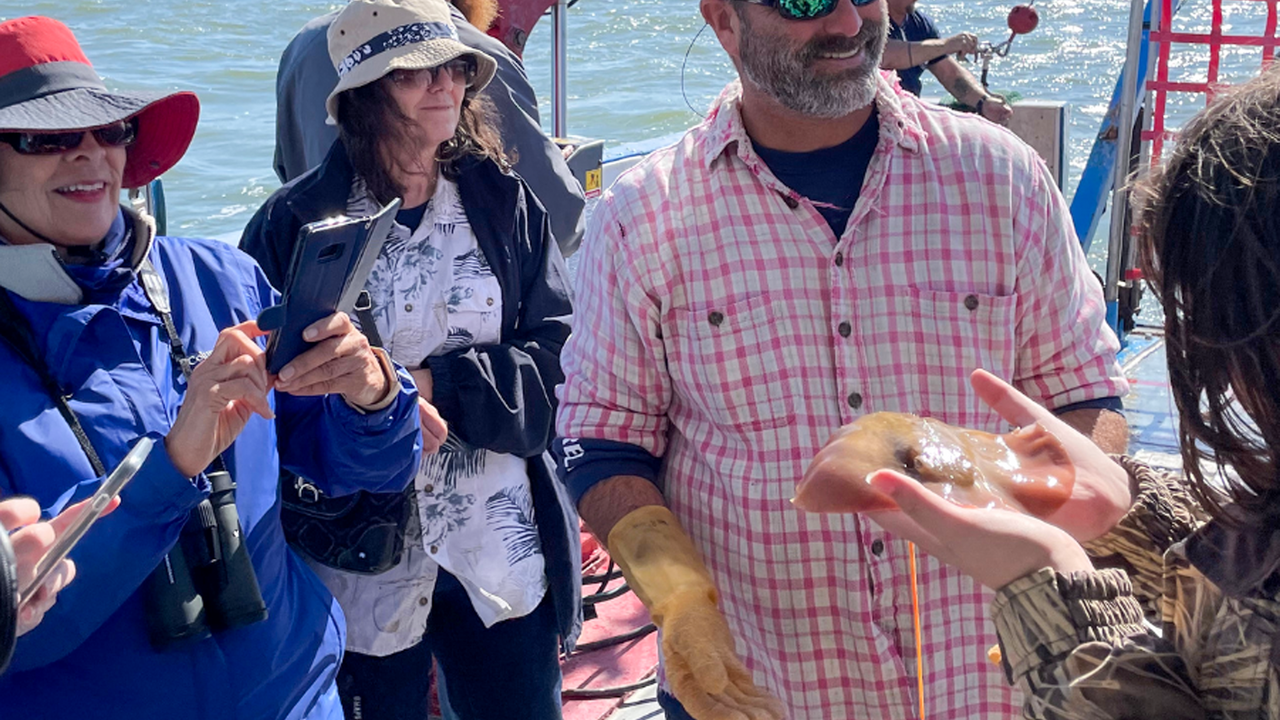 Man showing fish to group