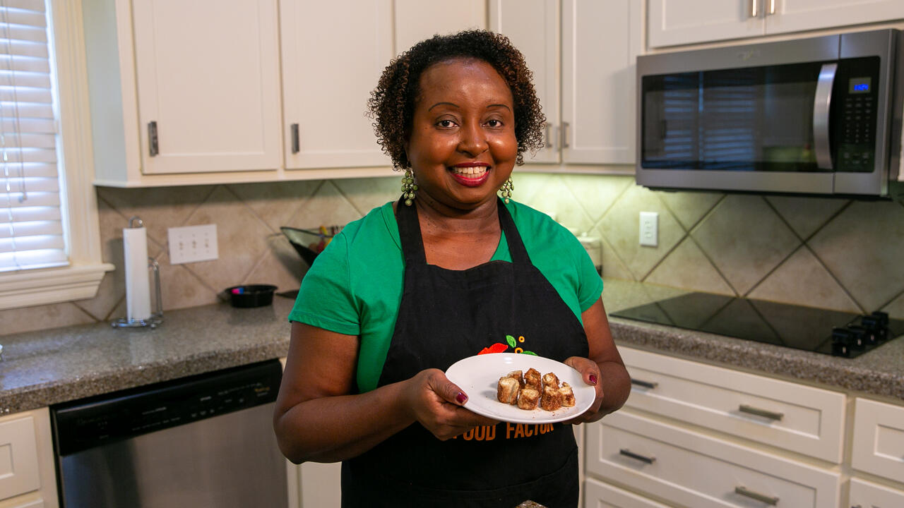 A woman in a kitchen holds a plate of Cinnamon Swirls.