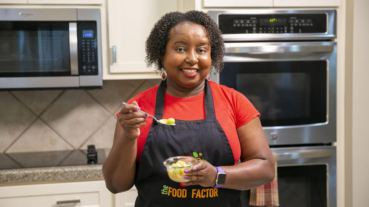 A woman stands in a kitchen with a bowl of Fruit Paradise