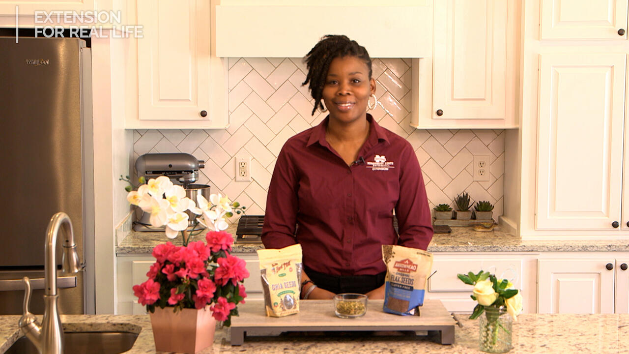 A woman stands at a kitchen counter.