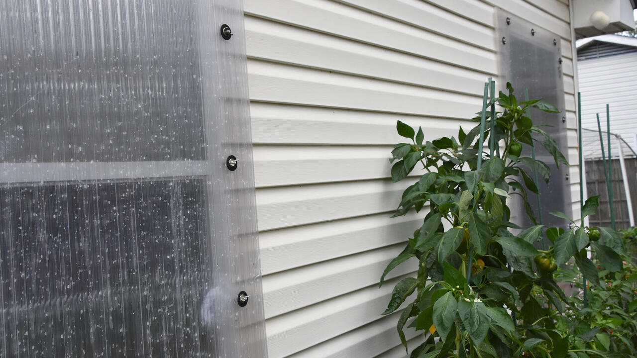 A clear panel covers a window on the exterior of a house.