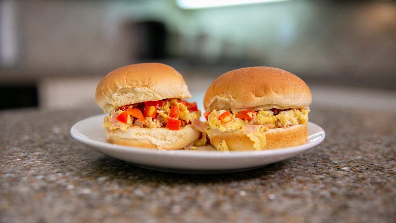 Two Microwave Denver Scramble Sliders sit on a plate on a kitchen countertop.