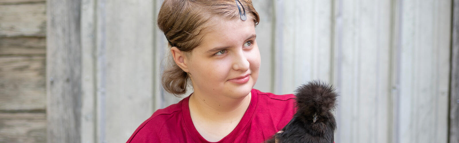 A child holding a chicken.