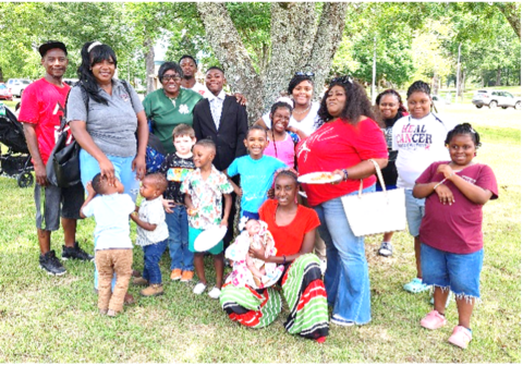 A family poses for a picture in front of a tree