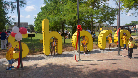 Children pose in front of a display spelling out `share`