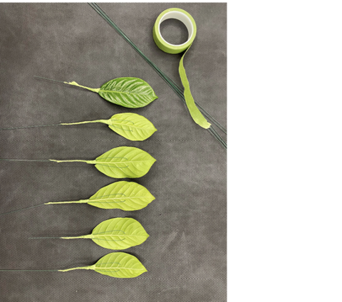 Six leaves lie on a surface beside floral wire and green floral tape. Five leaves are shown from underneath with wire stems attached and wrapped in floral tape; the sixth leaf is turned upward to show the finished top side.