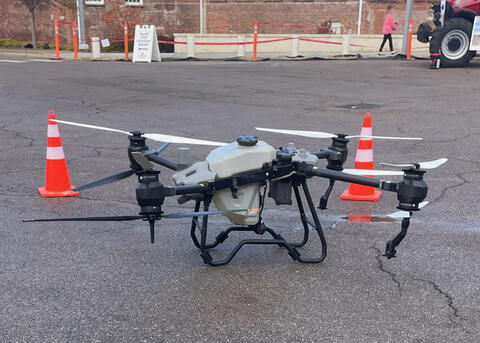 A large drone is displayed in a parking area.