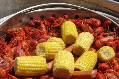 A pot of boiled crawfish and corn on the cob.