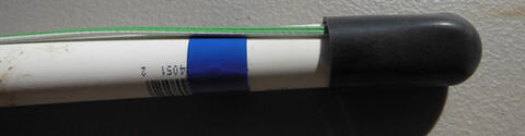 PVC pipe with a black rubber cap on one end and wires coming out of the cap along the length of the pipe.