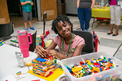 A girl building with LEGOs.