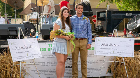 A woman wearing a tiara and holding a bouquet, standing beside a man wearing a polo.