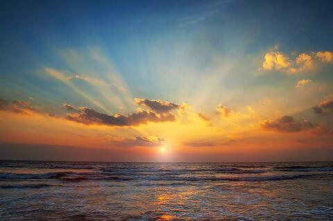 The warm colors of the sunrise mixing with the cooler blues of the sea and sky.