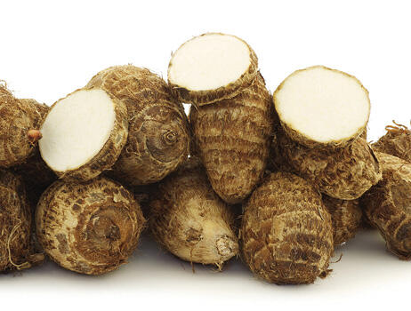 Four small, brown water taro rhizomes. They are oval-shaped and have a textured outer layer. 