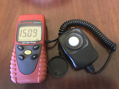 A cellphone-sized device with a remote attachment on a brown background.