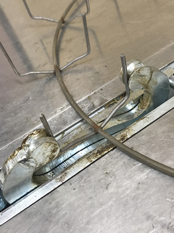Close-up of a single clamp mechanism on the wire wreath form.