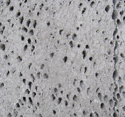 A closeup of a cool cell pad clogged with gray mineral buildup.