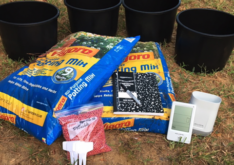 Four large pots, two bags of potting mix, a small bag of seeds, a notepad and marker, plant labels, and an electronic weather station.