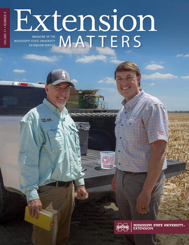 Two men standing next to an open pick up truck bed.