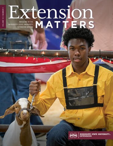 Young man next to a goat.