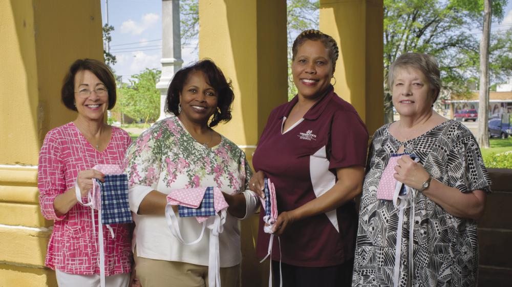 Docia England, Delta Cotton Belles member (left); Gladys Briggs, Mississippi Homemaker Volunteers member; Alma Harris, Washington County Extension agent; and Pat Word, MHV member and Washington County Extension office associate 4 women holding mastectomy drain pouch bags—small, square sacks laced with ribbon