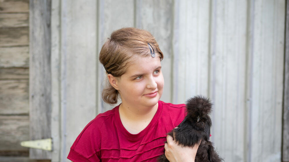 A child holding a chicken.
