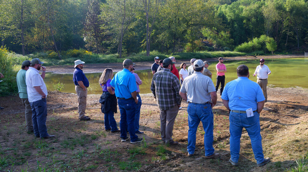 A group of people looking at an impoundment.