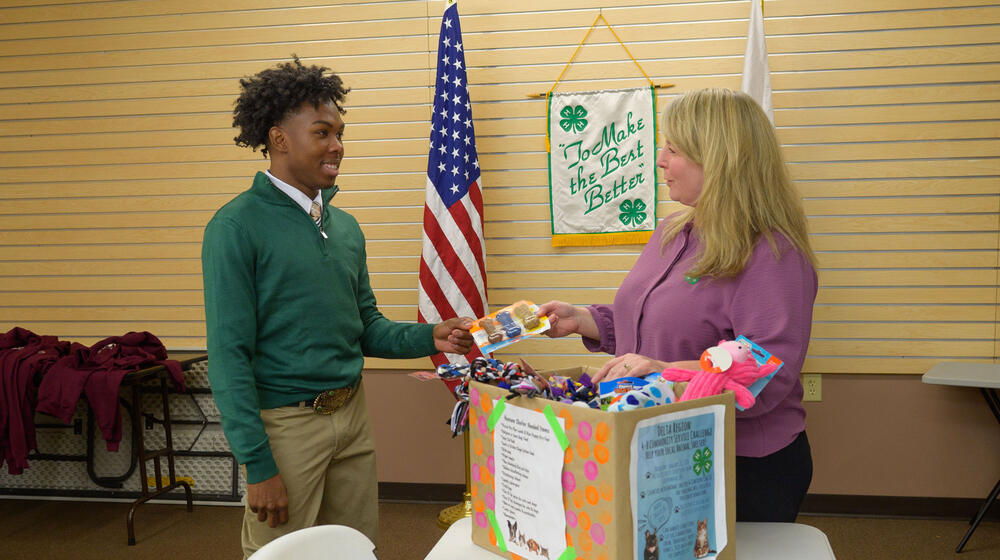 One person hands another person a package of dog bones.