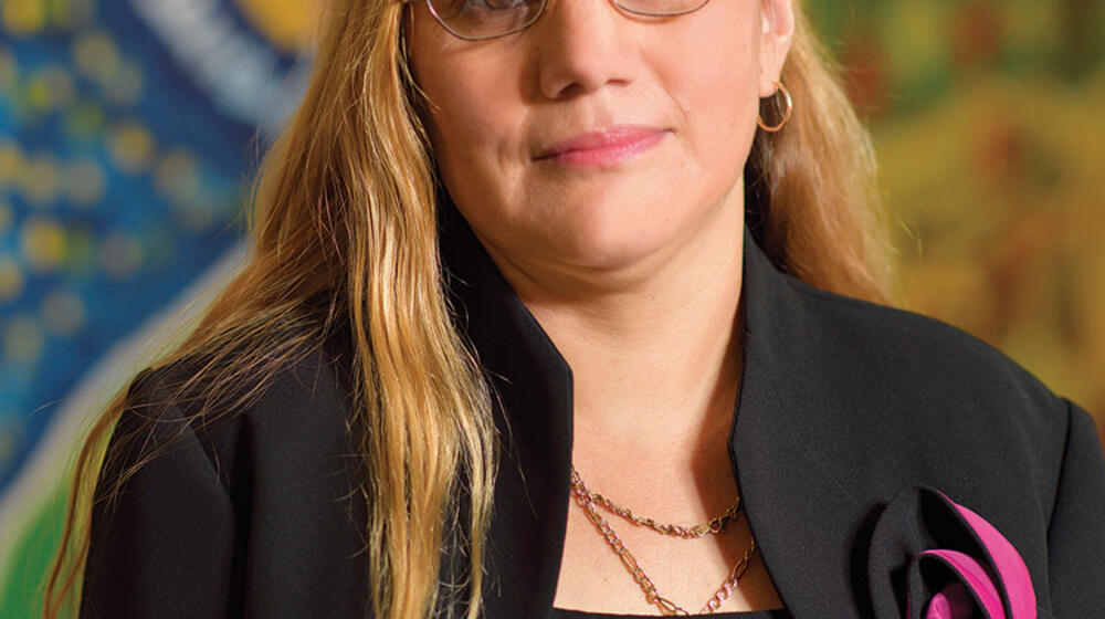 A woman wearing a black outfit smiles.
