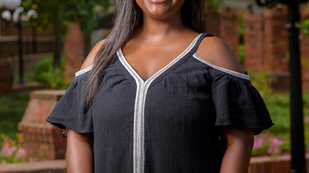 A young woman wearing a black shirt smiling.