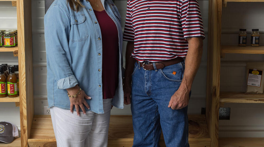 A man and woman standing next to each other, smiling for a photo.