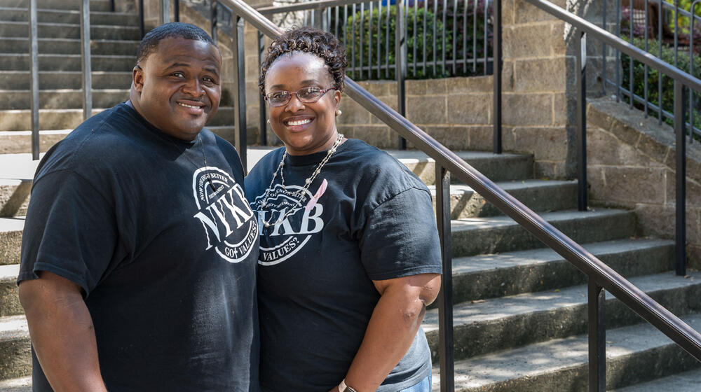 A man and woman standing in front of steps, smiling.