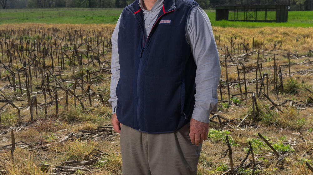 A man standing in a harvested field.
