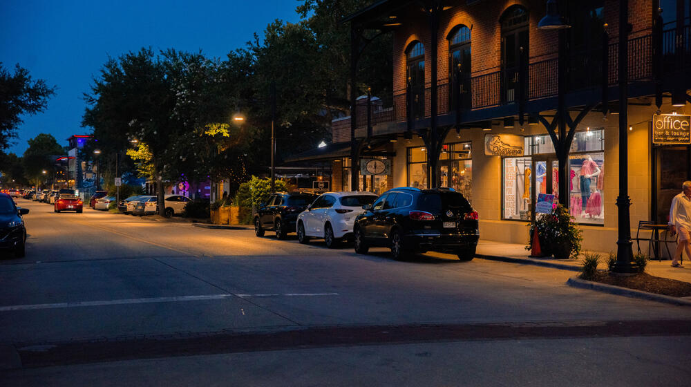 Downtown lights shining along the sidewalk.