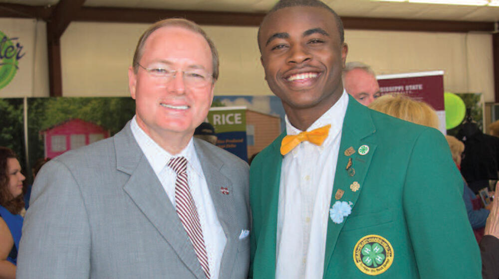 MSU President Mark Keenum stands next to a young man in a green 4-H blazer.