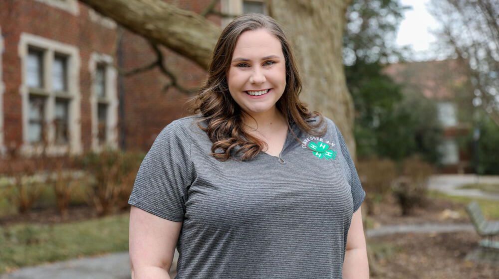 A standing woman smiling and wearing a Tennessee 4-H polo.