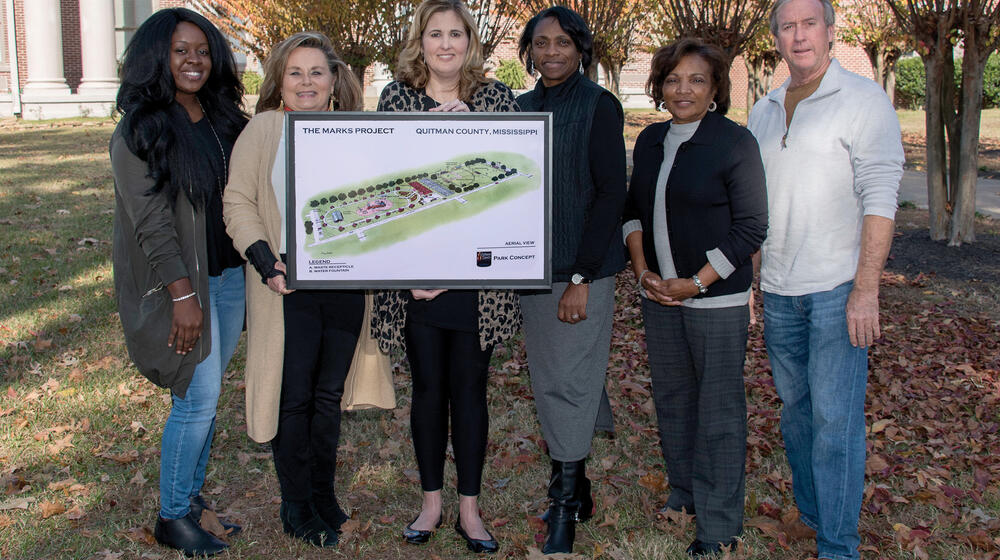 Members of The Marks Project in Quitman County hold a rendering of an improved community.