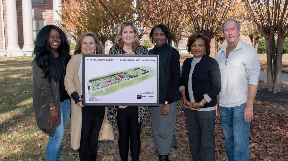 Members of The Marks Project in Quitman County hold a rendering of an improved community.