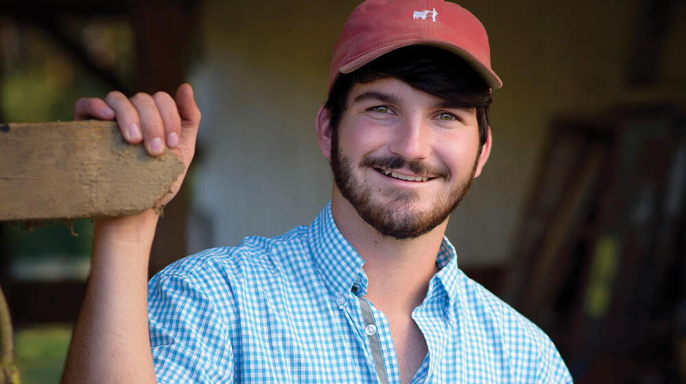 A young man wearing a cap and checked shirt.