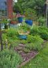 Blue containers hold plants in a landscape.