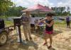 Jim McAdory, Mississippi State University Extension Service agent to the Mississippi Band of Choctaw Indians, shows Natasha Willis how to use the sunscreen dispenser provided by MSU Extension. The demonstration was part of a May 28 boating event in Neshoba County, Mississippi. (Photo by MSU Extension Service/Kevin Hudson)